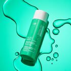 Multi-Action Clear Daily Brightening & Retexturizing Toner on textured green background